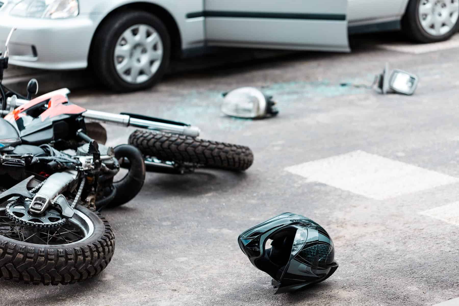 Overturned motorcycle and helmet on the street after collision with a car Overturned motorcycle and helmet on the street after collision with a car
