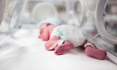 Newborn baby boy covered in vertix inside incubator Newborn baby boy covered in vertix inside incubator