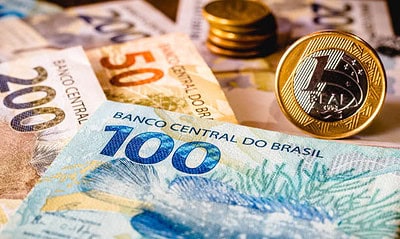 In this photo illustration being displayed one hundred and two hundred reais bills and a one reais coin highlighted. The Real is the current money in Brazil.