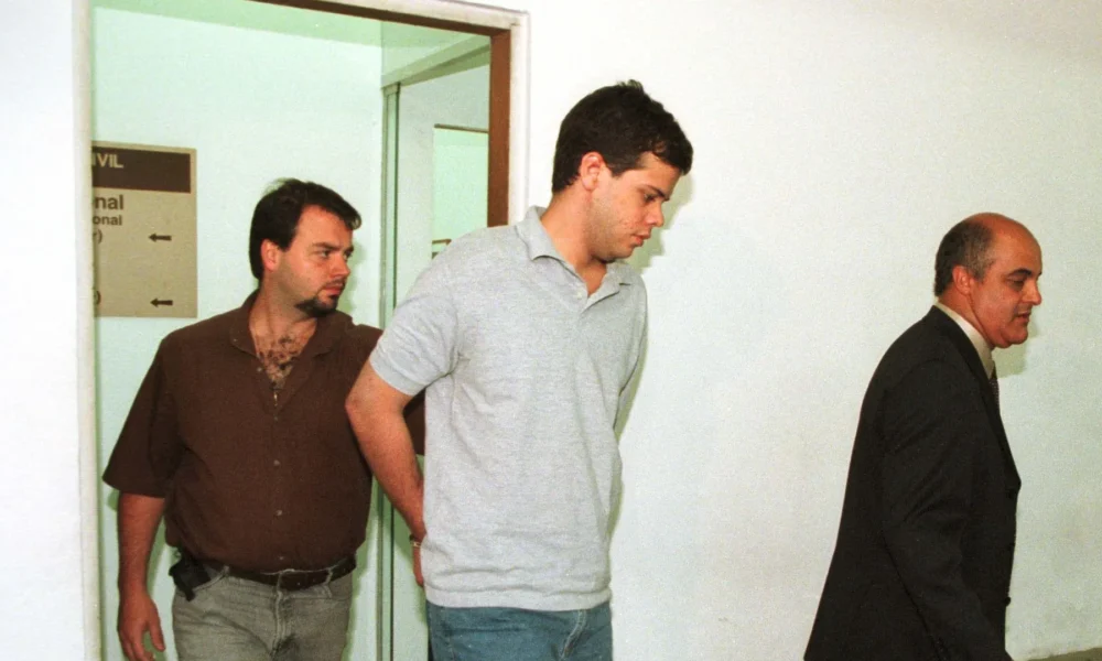 Mateus da Costa Meira (c), que matou 3 pessoas e deixou outras 4 feridas após disparar tiros de metralhadora em uma sala de cinema do Shopping Morumbi, é apresentado no 96º DP. • CAIO GUATELLI/ESTADÃO CONTEÚDO/AE