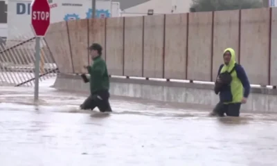 Pessoas caminham em meio a enchente em Valência Espanha • Reprodução/Reuters