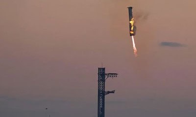 O foguete propulsor Super Heavy da SpaceX retorna à plataforma de lançamento para ser capturado pelos "hashis" de Mechazilla durante um voo de teste em 13 de outubro • Eric Gay/AP via CNN Newsource