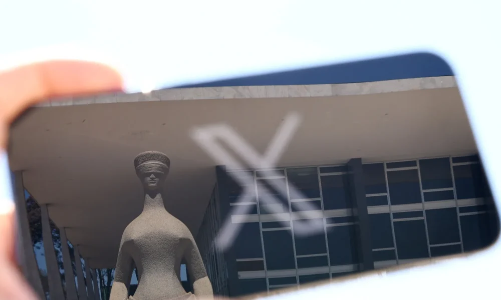 tagreuters.com2024binary_LYNXMPEK8P0QB-FILEDIMAGE Reflexo da fachada do STF em tela de celular em que aparece o logo da rede social X • 30/08/2024 REUTERS/Ueslei Marcelino