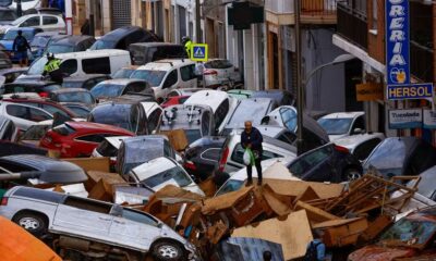 Homem caminha sobre carros arrastados por enchente histórica em Sedavi, Valência, na Espanha, em 31 de outubro de 2024 — Foto: Reuters/Susana Vera