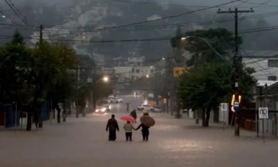 Moradores de bairro de Cavalhada, em Poro Alegre, caminham pela enchente (Foto: Diego Vara/Reuters)