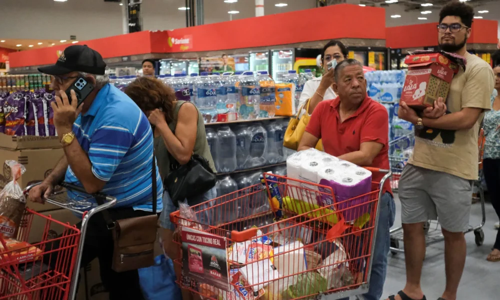 Pessoas fazem fila para comprar comida e suprimentos em supermercado de Cancún, no México, antes da passagem do furacão Milton • Paola Chiomante