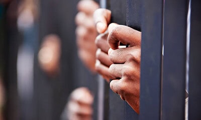Stolen life, group of hands African people behind bars holding them.