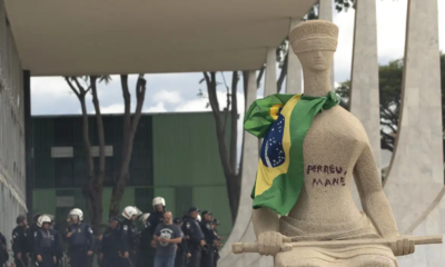 Débora Rodrigues sou um batom para pichar a frase "Perdeu, mané" na estátua "A Justiça", localizada na frente do Supremo Tribunal Federal (STF) (Joedson Alves/Agencia Brasil)