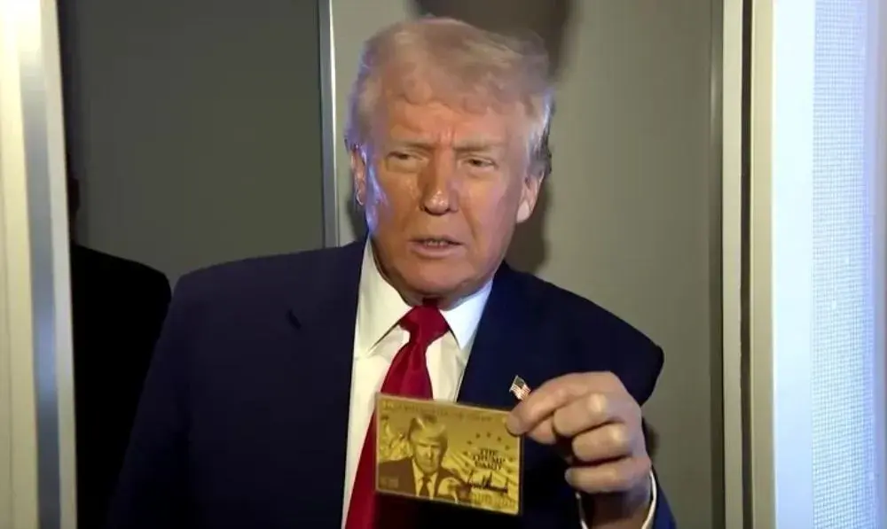 Trump segurando gold card. • Reprodução/Reuters