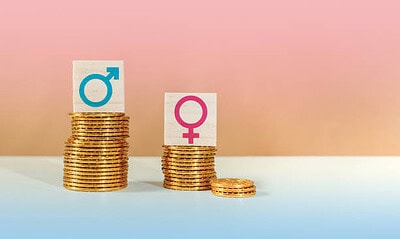 The symbols of male and female on piles of coins, gender pay equality concept