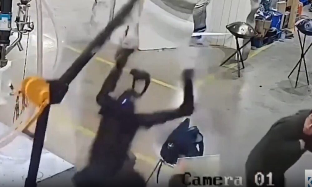 Um dos homens tenta conter o equipamento puxando o guindaste por trás, numa tentativa de evitar maiores danos (Foto: Reprodução/X)